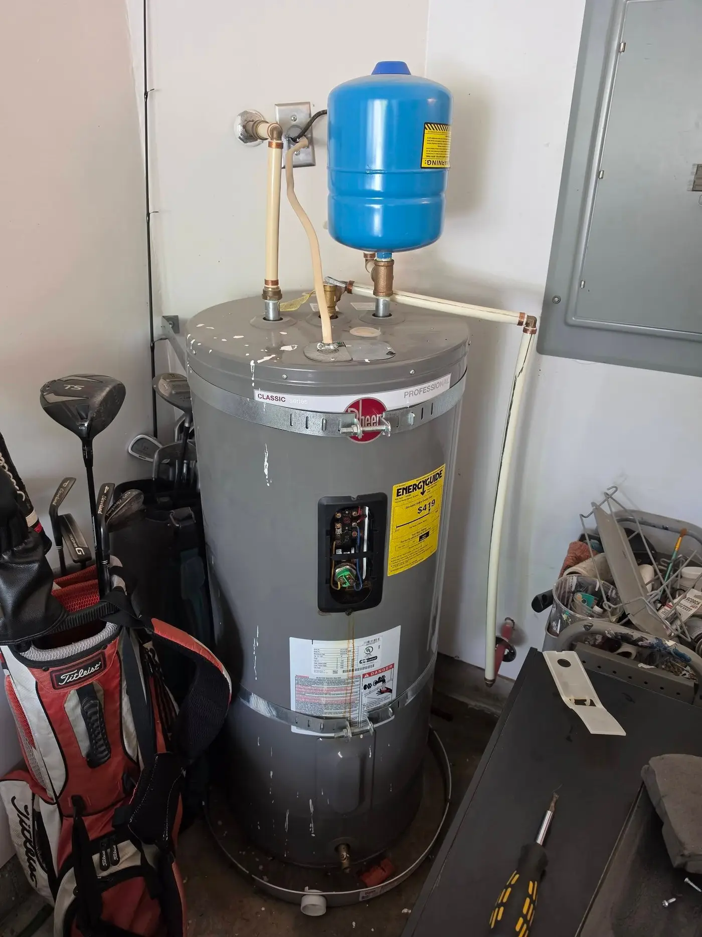 Hot water tank with an expansion tank mounted above it in a garage